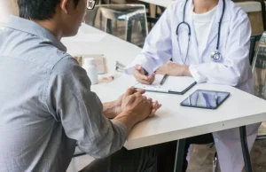 Paciente consultando con un médico en un entorno clínico, simbolizando una revisión médica tras un posible error médico grave.